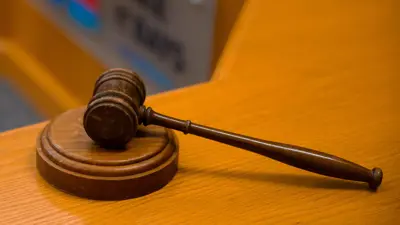 A wooden Mayor's gavel and sound block resting on a polished wooden surface.