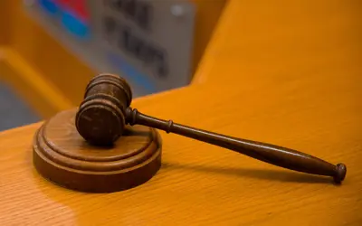 A wooden Mayor's gavel and sound block resting on a polished wooden surface.